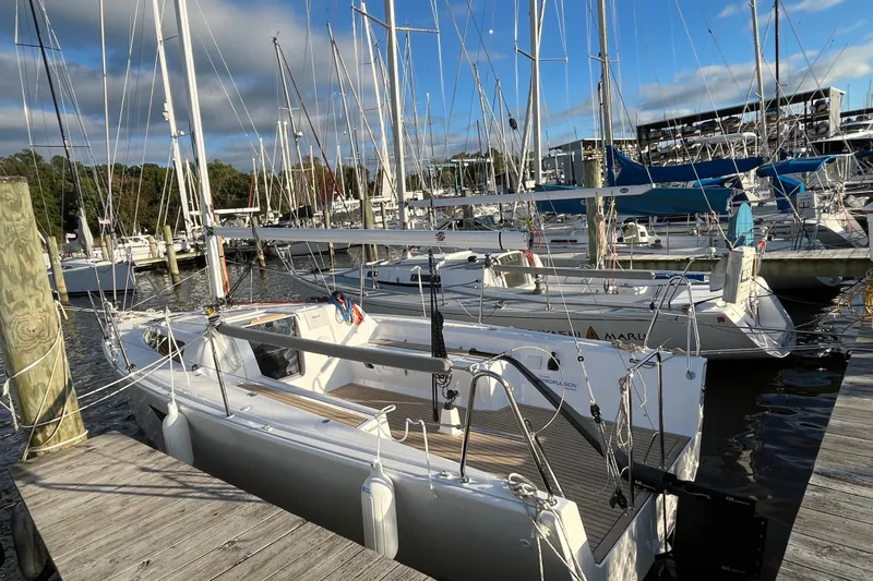 Z28 Yacht Photos Pics 2025 Zonda Yachts Z28 docked at marina, surrounded by sailboats under a partly cloudy sky.