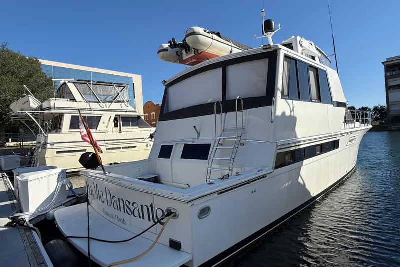 La Vie Dansante Yacht Photos Pics 1991 Californian 55 Cockpit Motor Yacht docked in a marina under clear blue skies.