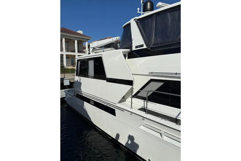 La Vie Dansante Yacht Photos Pics 1991 Californian 55 Cockpit Motor Yacht docked, showcasing sleek white exterior and modern design.