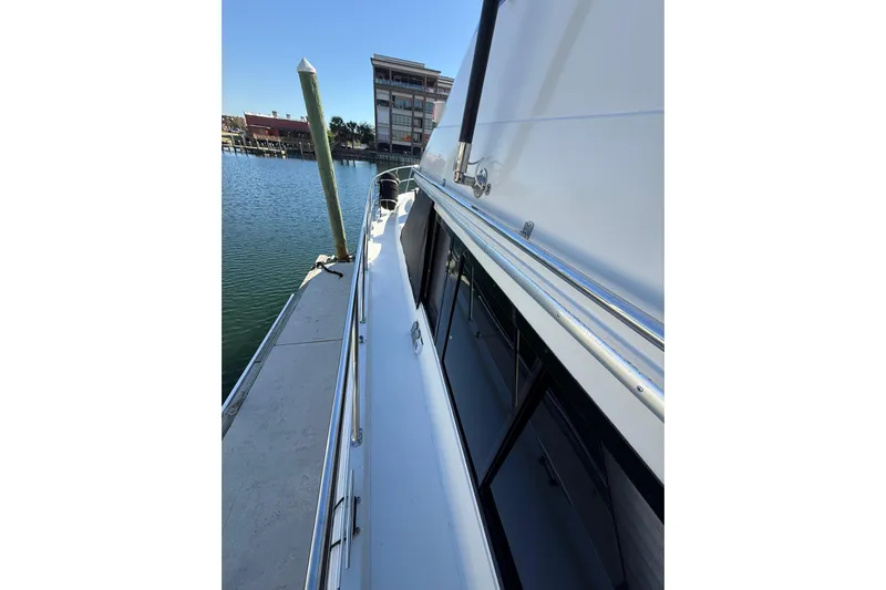 La Vie Dansante Yacht Photos Pics 1991 Californian 55 Cockpit Motor Yacht docked, showcasing sleek side view and marina backdrop.