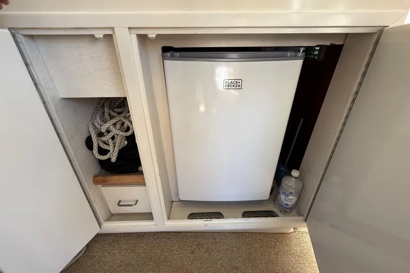 La Vie Dansante Yacht Photos Pics Compact fridge and storage in 1991 Californian 55 Cockpit Motor Yacht interior.