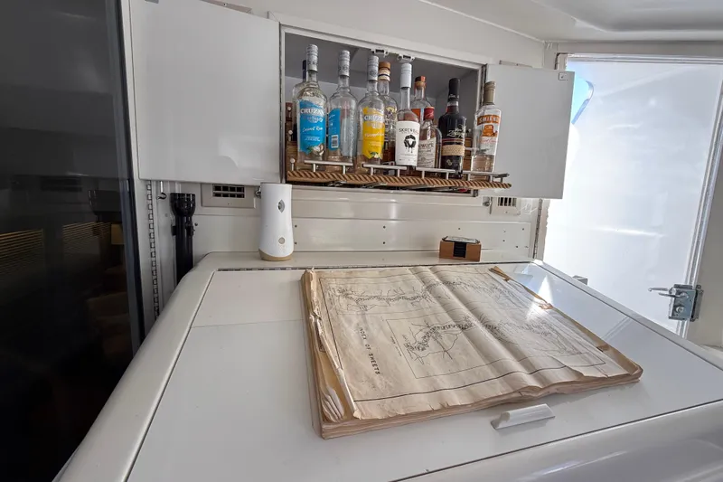 La Vie Dansante Yacht Photos Pics 1991 Californian 55 Cockpit Motor Yacht interior with liquor cabinet and nautical chart.