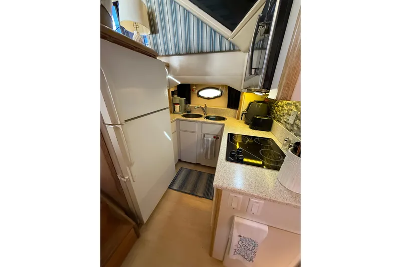 La Vie Dansante Yacht Photos Pics Compact kitchen in 1991 Californian 55 Cockpit Motor Yacht with modern appliances and cozy design.