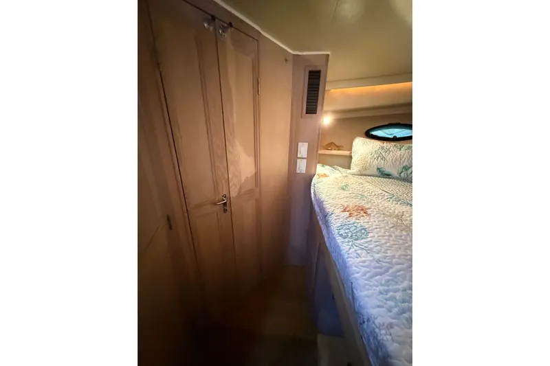 La Vie Dansante Yacht Photos Pics Interior cabin of 1991 Californian 55 Cockpit Motor Yacht with cozy bed and wooden closet.