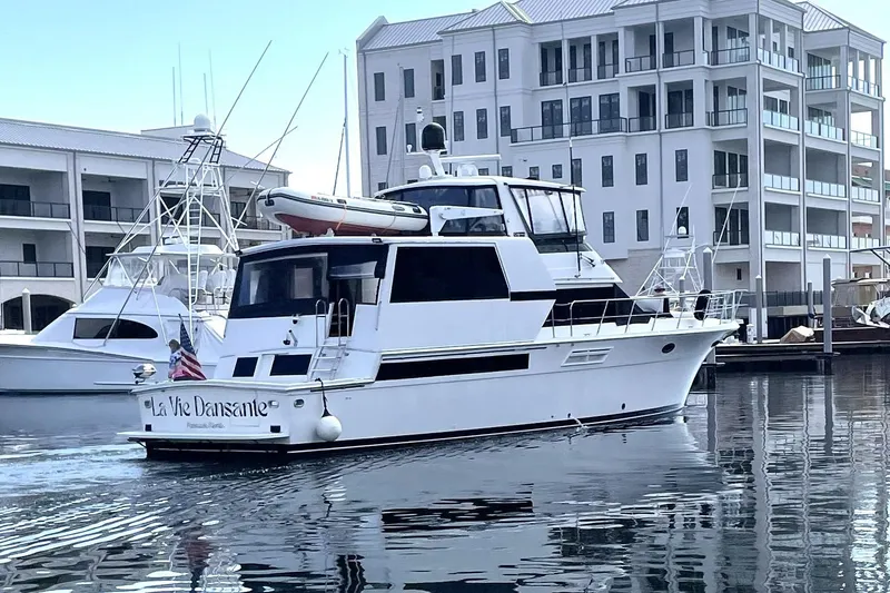 La Vie Dansante Yacht Photos Pics 1991 Californian 55 Cockpit Motor Yacht docked near modern buildings.