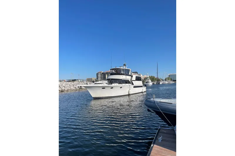 La Vie Dansante Yacht Photos Pics 1991 Californian 55 Cockpit Motor Yacht docked in a marina under clear blue skies.