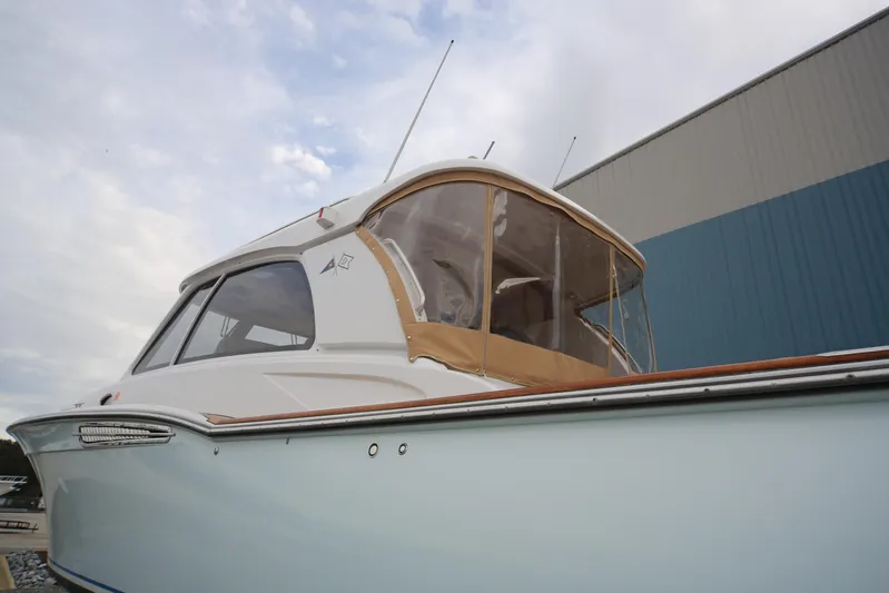 Mango Tango Yacht Photos Pics 2014 San Juan 41 yacht with enclosed cockpit, docked near a blue building.