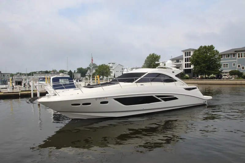  Yacht Photos Pics 2016 Sea Ray 510 Sundancer yacht docked in a marina, surrounded by buildings and trees.