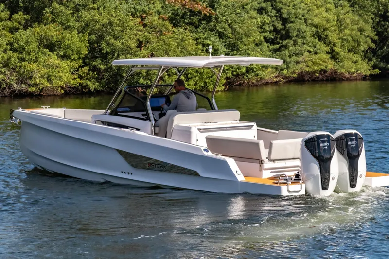  Yacht Photos Pics 2025 STERK 31 boat cruising on a serene waterway with lush greenery.
