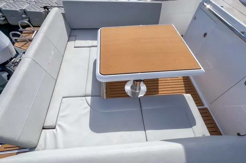  Yacht Photos Pics Luxurious seating area on 2025 STERK 31 boat with wooden table and cushioned seats.