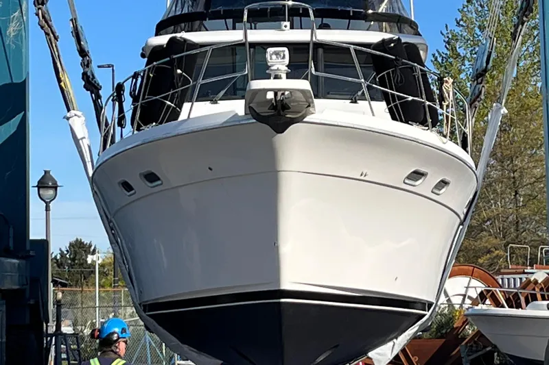 Sea Wolf Yacht Photos Pics 1994 Bayliner 4788 Pilot House Motoryacht being lifted, front view, outdoors.