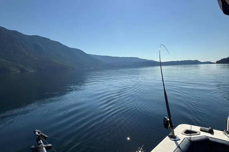 Sea Wolf Yacht Photos Pics Fishing from a 1994 Bayliner 4788 Pilot House Motoryacht on a serene lake.