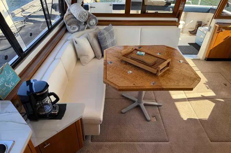 Sea Wolf Yacht Photos Pics Luxurious interior of 1994 Bayliner 4788 Pilot House Motoryacht with elegant seating and table.