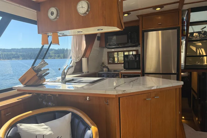 Sea Wolf Yacht Photos Pics Interior of 1994 Bayliner 4788 Pilot House Motoryacht kitchen with marble countertop and lake view.