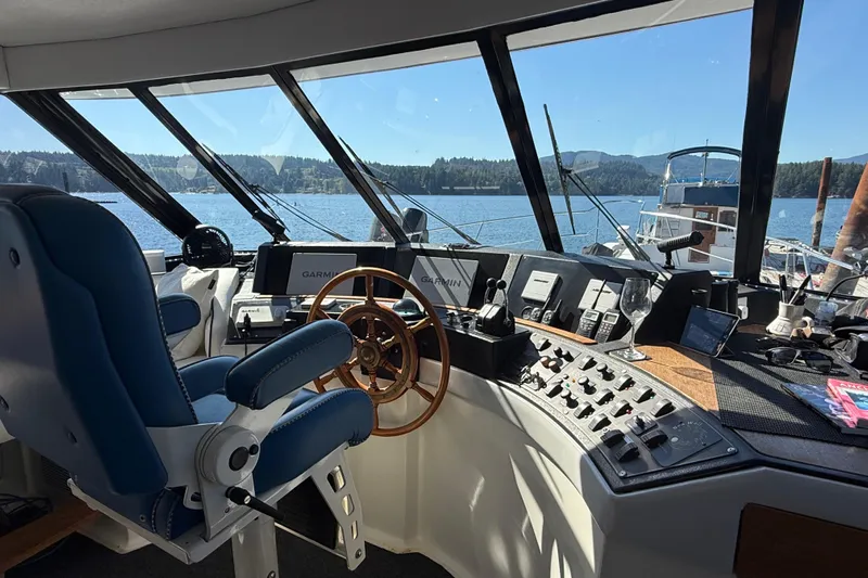 Sea Wolf Yacht Photos Pics 1994 Bayliner 4788 Pilot House Motoryacht helm with navigation equipment and scenic water view.