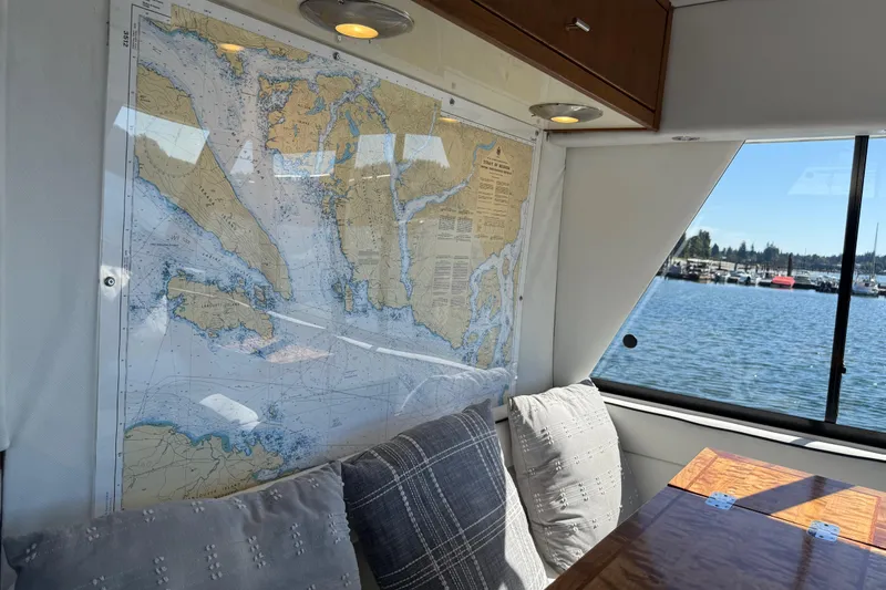 Sea Wolf Yacht Photos Pics Interior of 1994 Bayliner 4788 Pilot House Motoryacht with nautical chart and waterfront view.