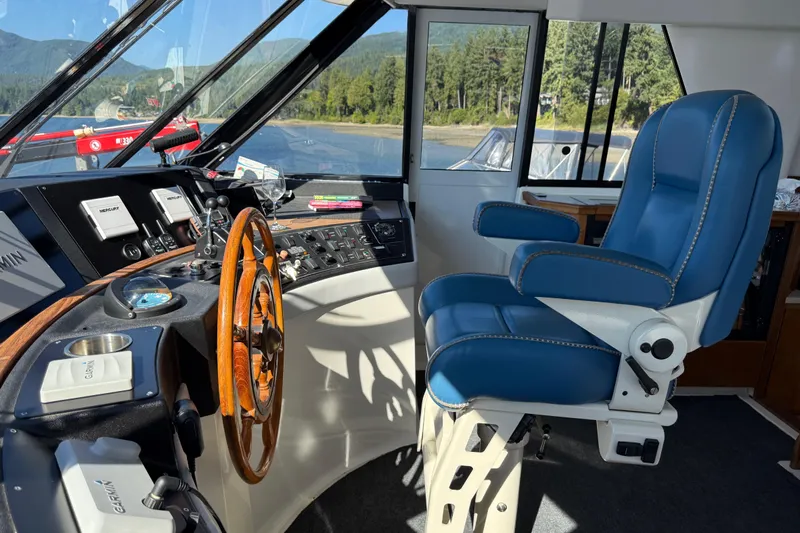 Sea Wolf Yacht Photos Pics Pilot house interior of 1994 Bayliner 4788 Motoryacht with blue captain's chair.