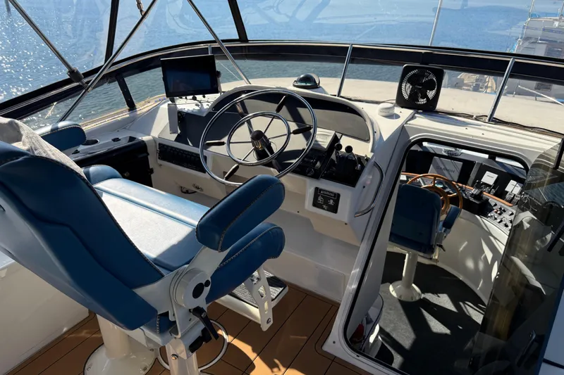 Sea Wolf Yacht Photos Pics 1994 Bayliner 4788 Pilot House Motoryacht helm with blue seating and navigation equipment.