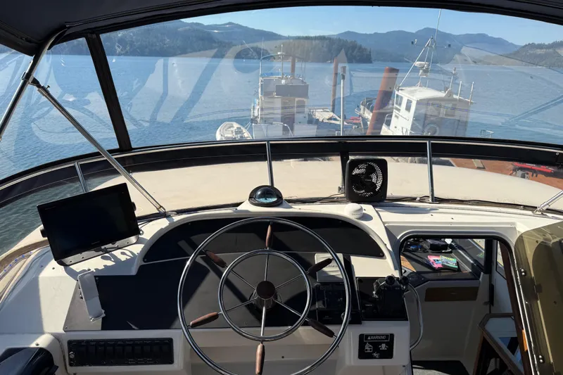 Sea Wolf Yacht Photos Pics 1994 Bayliner 4788 Pilot House Motoryacht helm with scenic water and mountain view.