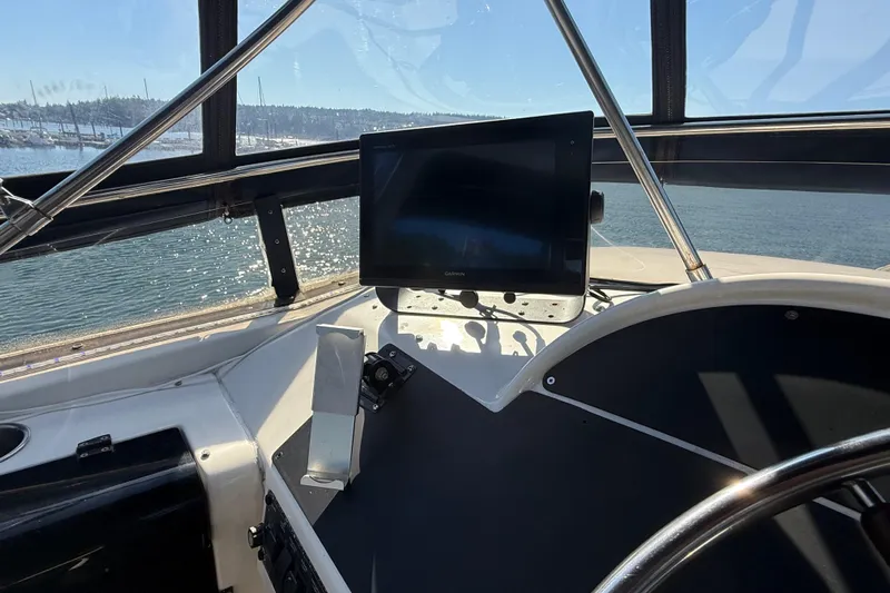 Sea Wolf Yacht Photos Pics 1994 Bayliner 4788 Pilot House Motoryacht helm with navigation display, overlooking serene waters.