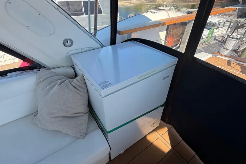 Sea Wolf Yacht Photos Pics 1994 Bayliner 4788 Pilot House Motoryacht interior with white seating and compact refrigerator.