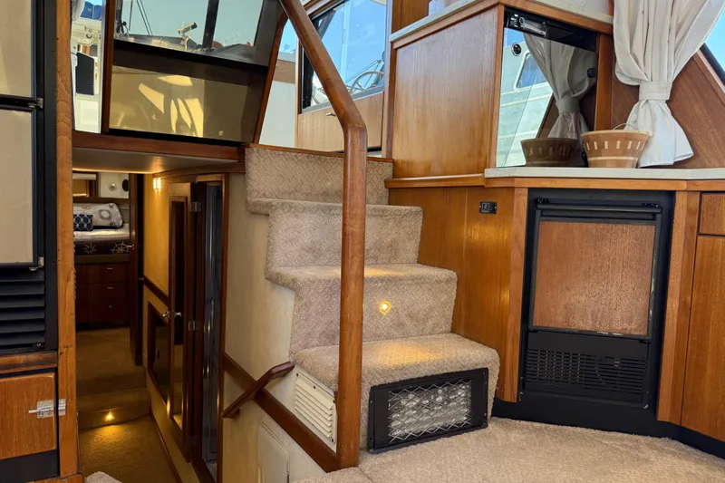 Sea Wolf Yacht Photos Pics Interior of 1994 Bayliner 4788 Pilot House Motoryacht with carpeted stairs and wooden accents.