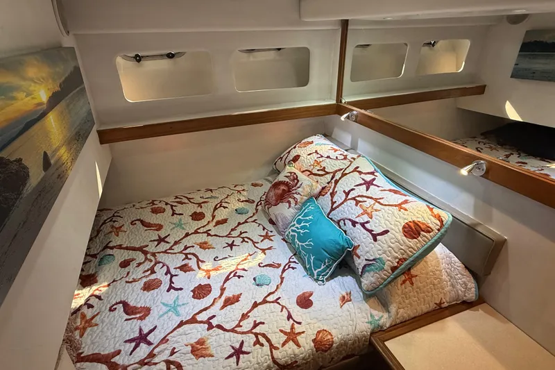 Sea Wolf Yacht Photos Pics Cozy bedroom in 1994 Bayliner 4788 Pilot House Motoryacht with nautical-themed bedding.