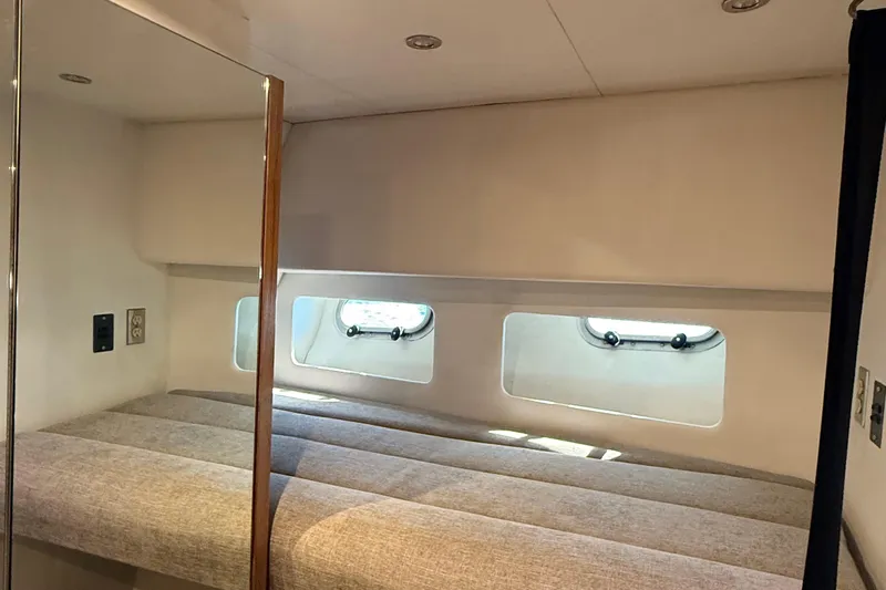 Sea Wolf Yacht Photos Pics Interior cabin of 1994 Bayliner 4788 Pilot House Motoryacht with windows and cushioned seating.