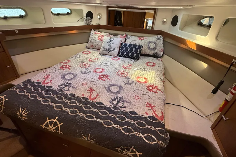 Sea Wolf Yacht Photos Pics Cozy bedroom in 1994 Bayliner 4788 Pilot House Motoryacht with nautical-themed bedding.