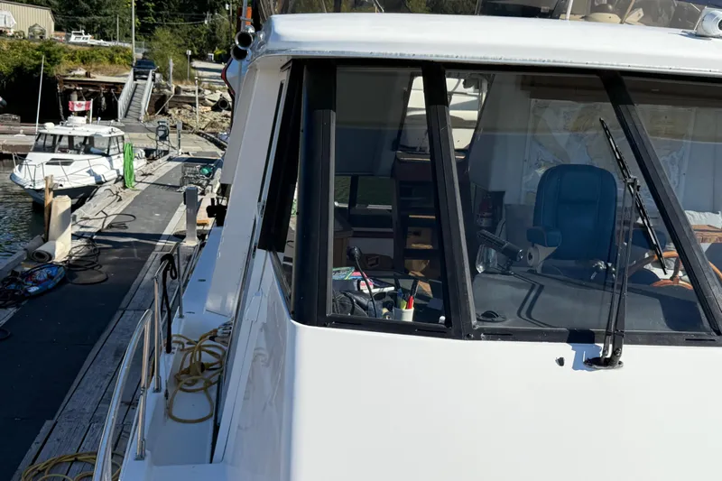 Sea Wolf Yacht Photos Pics 1994 Bayliner 4788 Pilot House Motoryacht docked, showcasing helm and marina surroundings.