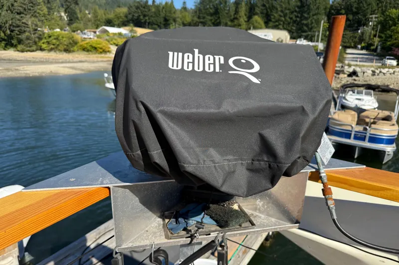 Sea Wolf Yacht Photos Pics Weber grill on 1994 Bayliner 4788 Pilot House Motoryacht, docked by scenic waterfront.