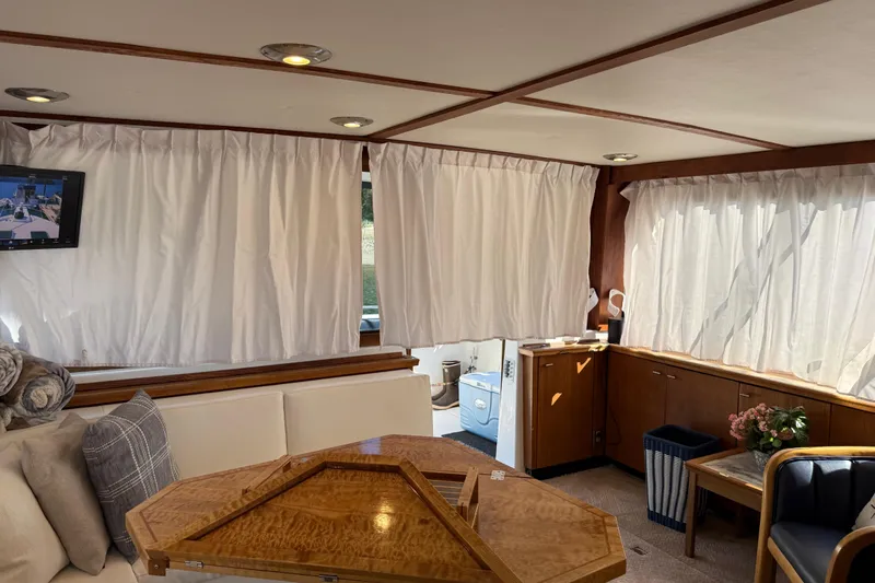 Sea Wolf Yacht Photos Pics Interior of 1994 Bayliner 4788 Pilot House Motoryacht with elegant wood table and cozy seating.