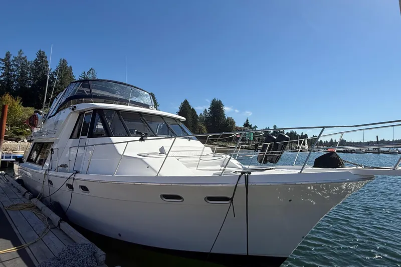 Sea Wolf Yacht Photos Pics 1994 Bayliner 4788 Pilot House Motoryacht docked on a sunny day.