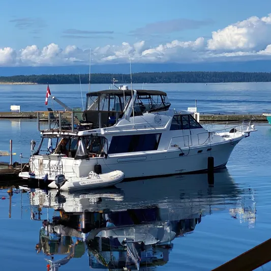 Sea Wolf Yacht Photos Pics 1994 Bayliner 4788 Pilot House Motoryacht docked on calm water with clear sky.