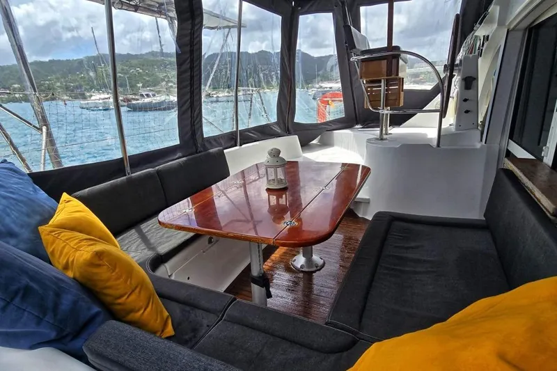 Alego Yacht Photos Pics Interior of 2007 Lagoon 380 S2 catamaran with cozy seating and wooden table.