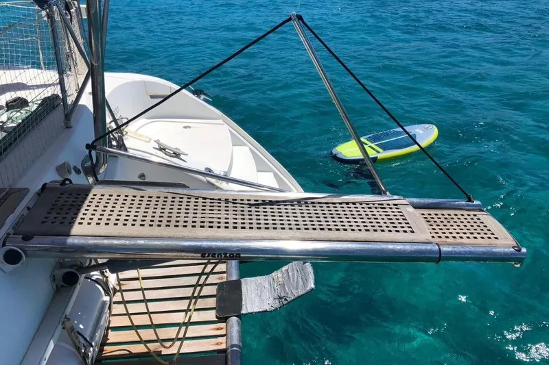 Alego Yacht Photos Pics Lagoon 380 S2 yacht with swim platform and paddleboard on clear blue water.