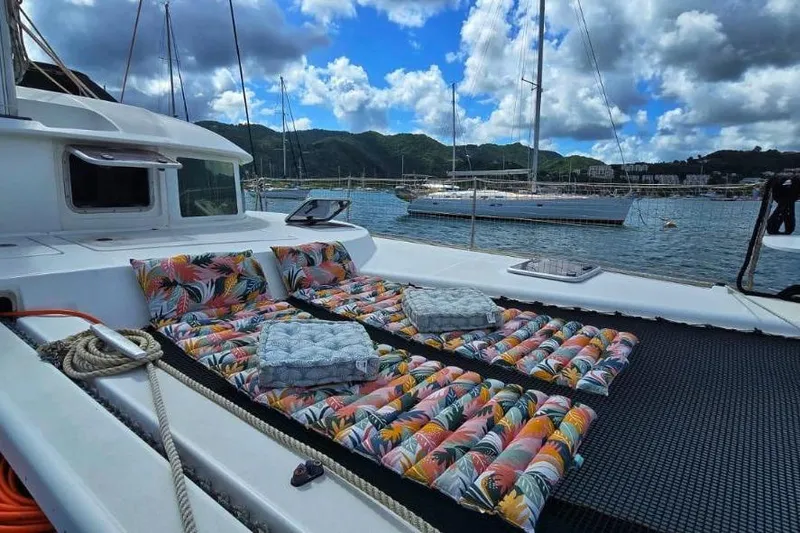 Alego Yacht Photos Pics 2007 Lagoon 380 S2 catamaran with colorful cushions, docked in a scenic marina.