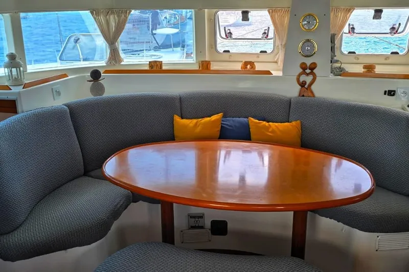 Alego Yacht Photos Pics Cozy interior of 2007 Lagoon 380 S2 catamaran with round table and cushioned seating.