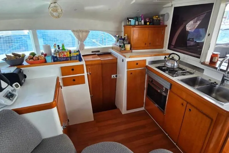 Alego Yacht Photos Pics Interior of 2007 Lagoon 380 S2 yacht kitchen with wooden cabinets and appliances.