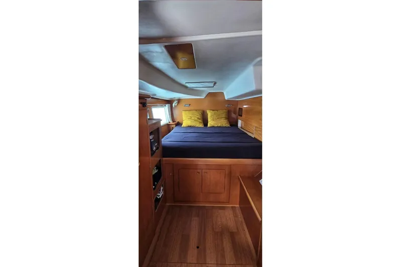 Alego Yacht Photos Pics Interior cabin of 2007 Lagoon 380 S2 catamaran with cozy bed and wooden furnishings.