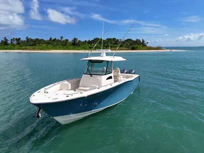  Yacht Photos Pics 2021 Grady-White Canyon 336 boat on clear blue water near a tropical island.