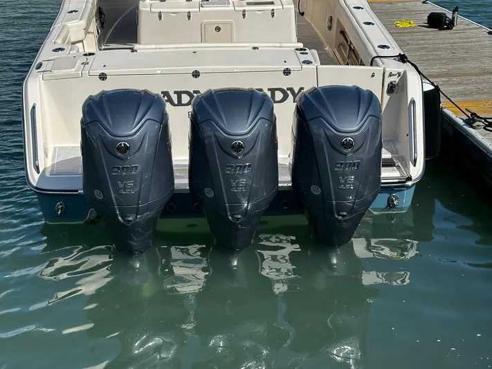 Yacht Photos Pics 2021 Grady-White Canyon 336 boat with triple outboard engines docked in water.