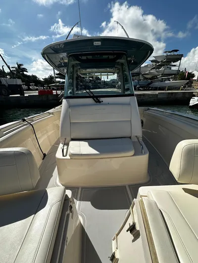  Yacht Photos Pics 2021 Grady-White Canyon 336 boat interior with seating, docked under a sunny sky.