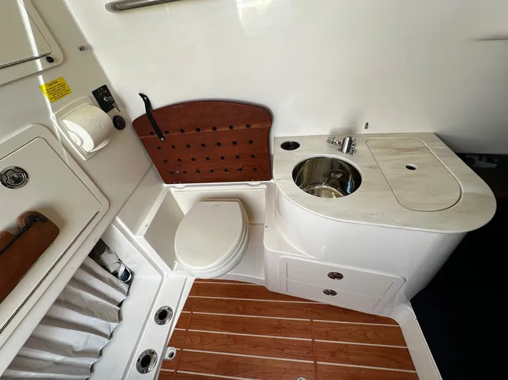  Yacht Photos Pics 2021 Grady-White Canyon 336 boat bathroom with sink, toilet, and wooden flooring.