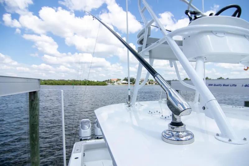  Yacht Photos Pics 2022 Freeman 37 VH boat with fishing rod holder, docked by a scenic waterfront.