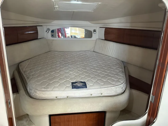  Yacht Photos Pics 2004 Sea Ray 360 Sundancer cabin with a cozy bed and wooden accents.