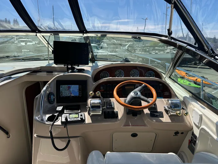  Yacht Photos Pics 2004 Sea Ray 360 Sundancer helm with navigation equipment and wooden steering wheel.