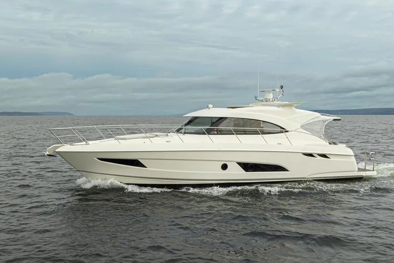 Lucky Dog Yacht Photos Pics 2018 Riviera 4800 Sport Yacht cruising on open water under cloudy skies.