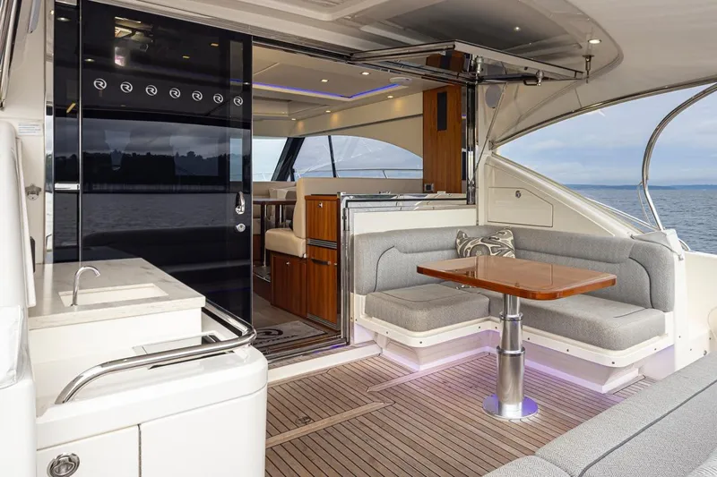 Lucky Dog Yacht Photos Pics Luxurious 2018 Riviera 4800 Sport Yacht interior with elegant seating and ocean view.