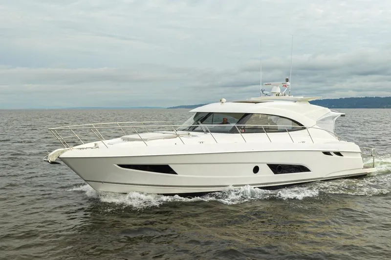 Lucky Dog Yacht Photos Pics 2018 Riviera 4800 Sport Yacht cruising on open water under cloudy skies.